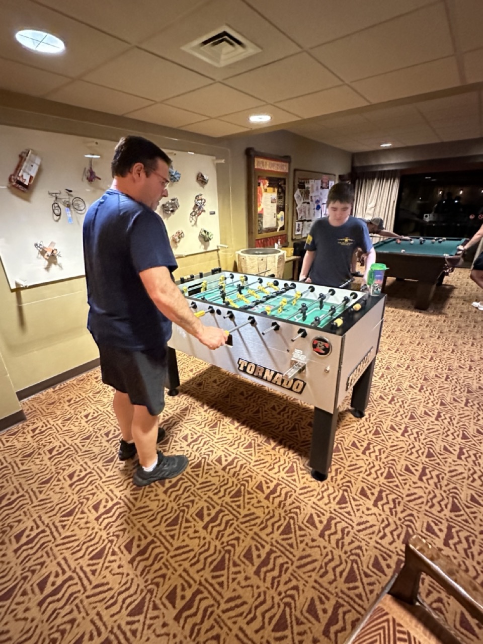 Teenager and parent playing foosball in a recreation area at a Walt Disney World Resort hotel